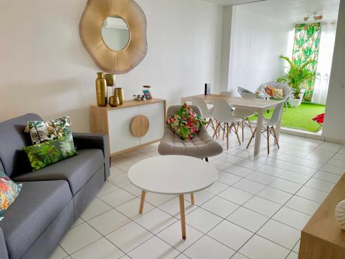 uma sala de estar com um sofá e uma mesa em Appartement de la Mer et du Levant em Schœlcher