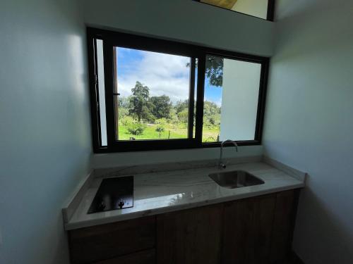 a bathroom with a sink and a window at Aires de Quetzales in Concepción