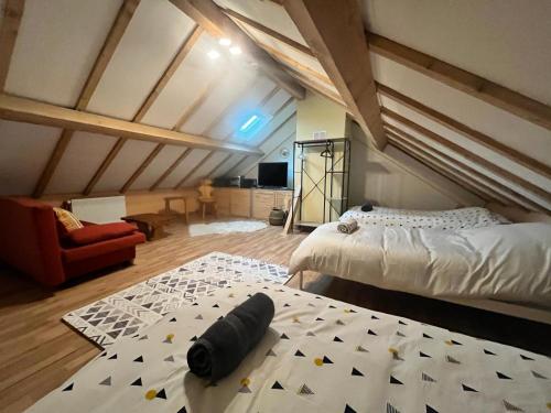 - une chambre mansardée avec un lit et un tapis dans l'établissement L’atelier des rêves, à Volmunster