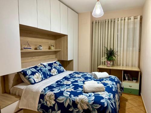 a bedroom with a bed with a blue and white blanket at SkyView Oasis Premium Apartment in Tirana