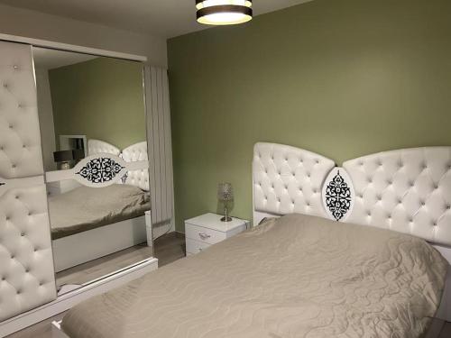 ein Schlafzimmer mit einem Bett und einem großen Spiegel in der Unterkunft Maison entière in Cébazat