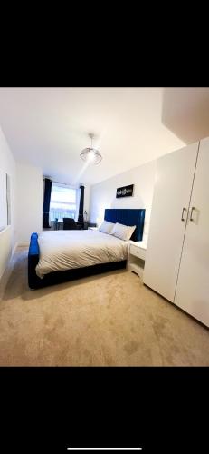 a bedroom with a large bed and a desk at Stylish + Peaceful 2 bed/2bath in Slades Green