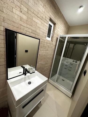 a bathroom with a white sink and a mirror at Дом с потрясающим видом in Almaty