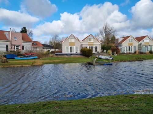 een groep huizen met boten in het water bij Prachtige vakantievilla aan IJsselmeer Makkum in Makkum