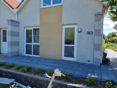 een huis met een patio ervoor bij Prachtige vakantievilla aan IJsselmeer Makkum in Makkum