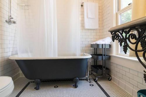 a bathroom with a black tub and a toilet at iKlektik House / Bagley in Detroit