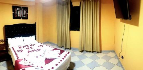 1 dormitorio con 1 cama con manta roja y blanca en HOSPEDAJE RINCONCITO, en Tacna