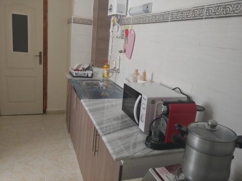 a kitchen with a counter top with a microwave on it at Appartement F3 Fil-Fila Skikda in Skikda