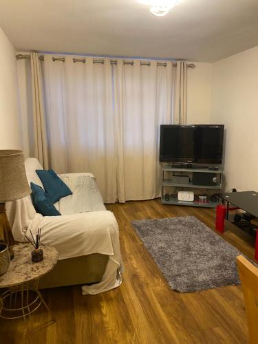 1 dormitorio con 1 cama y TV de pantalla plana en Lovely, spacious 1-bedroom apartment with *free parking, en Mánchester