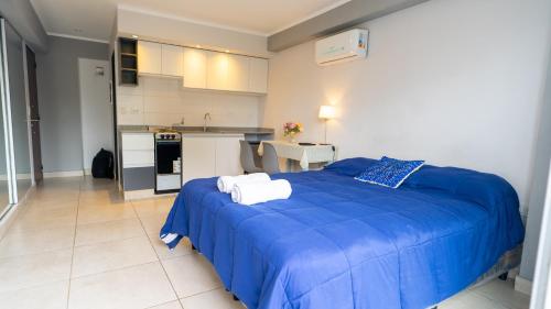 1 dormitorio con 1 cama azul y cocina en Altos de Alvear en Salta