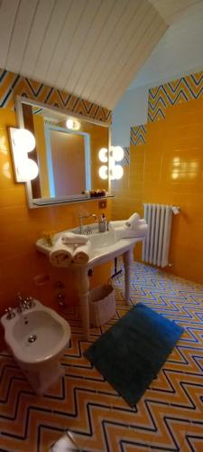 a bathroom with a sink and a toilet and a mirror at Villa Pieve in Moncalvo
