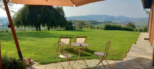 a table and chairs sitting under an umbrella at Villa Pieve in Moncalvo