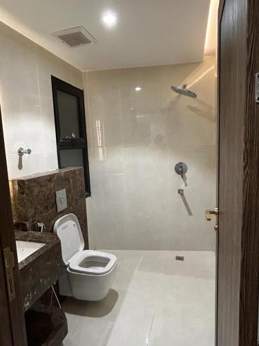 a bathroom with a toilet and a sink at فندق دعاء2 in Al Hindāwīyah
