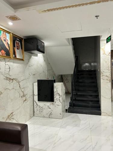 a lobby with a staircase and a television in a room at فندق دعاء2 in Al Hindāwīyah
