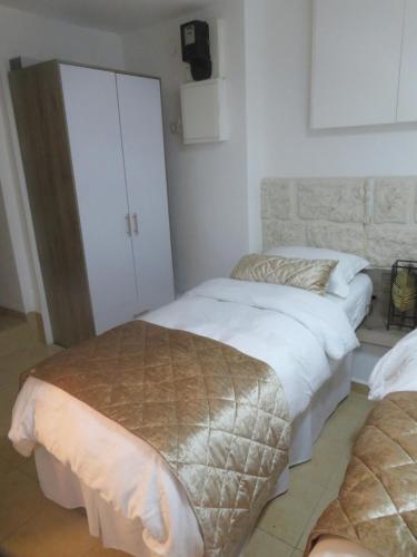 a bedroom with two beds and a white cabinet at Self-Contained Garden apartment with Galilee sea & mountains view 2 in Safed