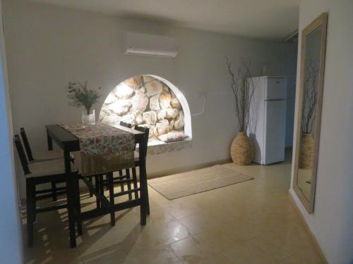 a dining room with a table and a stone wall at Self-Contained Garden apartment with Galilee sea & mountains view 2 in Safed