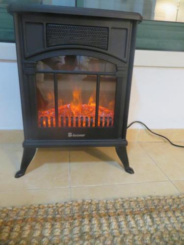 a black fireplace sitting on top of a floor at Self-Contained Garden apartment with Galilee sea & mountains view 2 in Safed