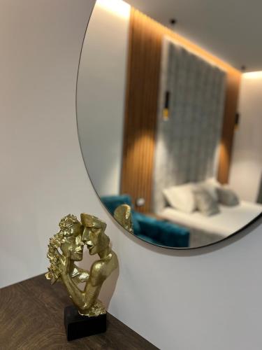 a gold statue sitting on a table in front of a mirror at Julies Vila in Ksamil