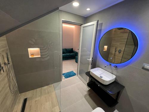 een badkamer met een wastafel en een spiegel bij Julies Vila in Ksamil