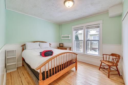 a bedroom with a bed and a chair and a window at Ludington Home with 6 Bicycles Less Than 1 Mi to Beach! in Ludington