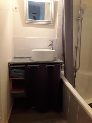 Appartement à 100 mètres de la plage في اويسترهام: حمام مع حوض ومرآة وحوض استحمام