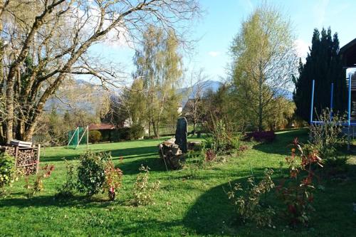 a garden with a statue in the grass at Chalet avec grand jardin en Chartreuse Alpes in Miribel-les-Échelles