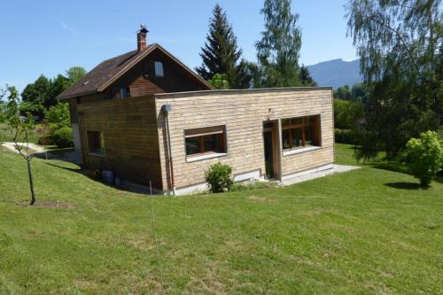 a small wooden house in a field of grass at Chalet avec grand jardin en Chartreuse Alpes in Miribel-les-Échelles
