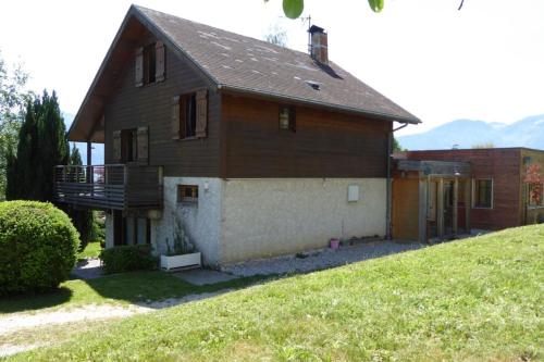 a brown house with a balcony and a yard at Chalet avec grand jardin en Chartreuse Alpes in Miribel-les-Échelles