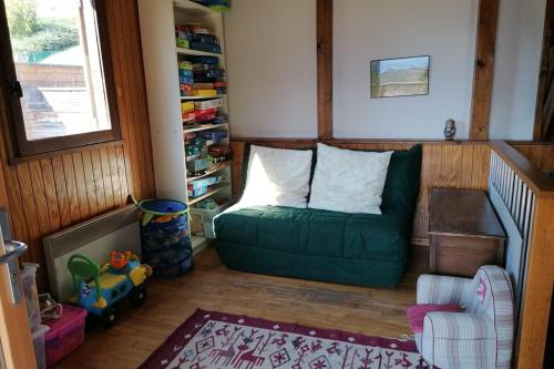 a living room with a green couch and a chair at Chalet avec grand jardin en Chartreuse Alpes in Miribel-les-Échelles