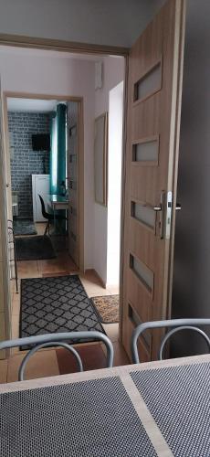 a door to a room with a bed and a table at Pokoje AGA in Mikołajki