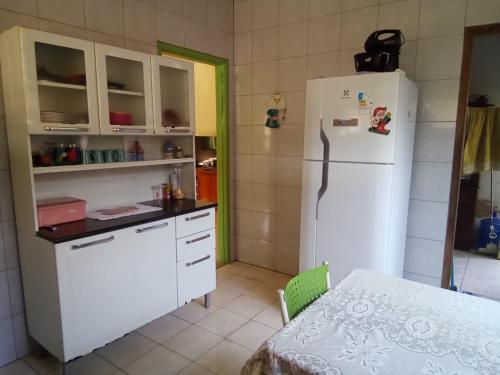 a kitchen with a white refrigerator and a table at CASA MJ HOSPEDAGEM in Porto Velho
