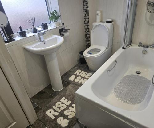 a bathroom with a toilet and a tub and a sink at Aldwych house, For Holidays, Contractors & Relocation, Free Parking & Wi-Fi in Preston