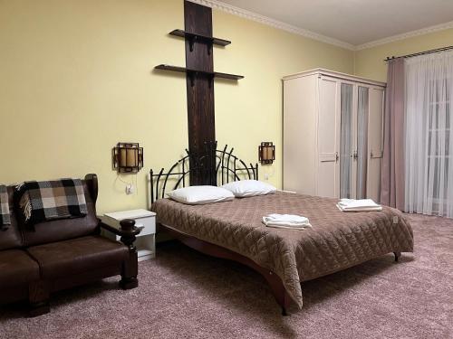 a bedroom with a bed and a cross on the wall at U Dominicana in Kamianets-Podilskyi