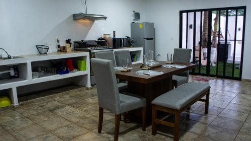 a kitchen with a table and chairs in a kitchen at Villa Tataya Nawi in Monte Gordo