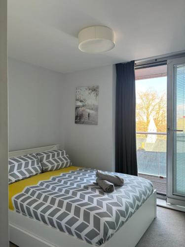 um quarto com uma cama e uma grande janela em LUXURY Leicester apartment em Leicester