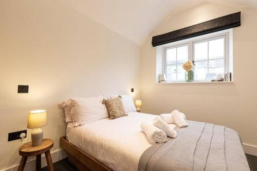 1 dormitorio con 1 cama con sábanas blancas y ventana en The Bothy, en Ulverston