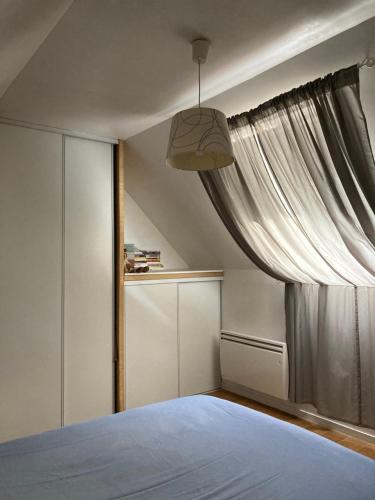 une chambre avec un lit et une fenêtre dans l'établissement Chez Suzanne, à Écouen