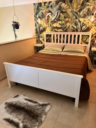 1 dormitorio con 1 cama blanca con manta marrón en Piazzetta 42 Holiday Room, en Trani