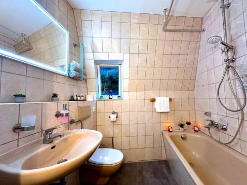 a bathroom with a sink and a tub and a toilet at Boutique Apartment • Zentrum • Netflix • Parkplatz in Bad Schandau