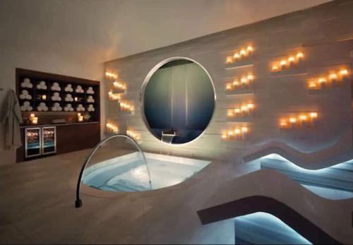 a bathroom with a tub with a mirror and lights at Corner Suite at Vdara Hotel and Spa in Las Vegas