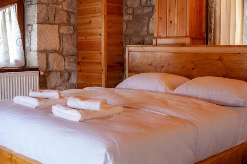 a bedroom with a bed with towels on it at Vila Nikol in Voskopojë