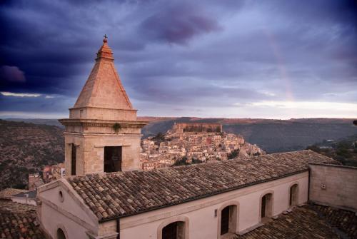 a building with a tower with a city in the background at Le Sirene B&B in Ragusa