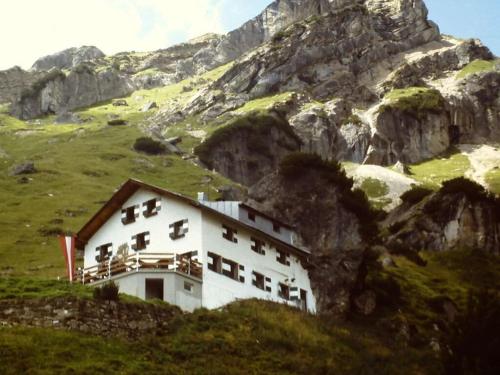a white building on a hill with a mountain at Holiday apartment Haus Frank in Nassereith