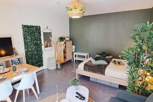 a living room with a bed and a table and a room at Petit cocon nature centre-ville in Colmar