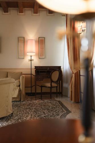 a living room with a desk and a couch at Hotel Villa Policreti in Castello dʼAviano