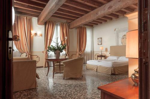 a hotel room with a bed and a table at Hotel Villa Policreti in Castello dʼAviano