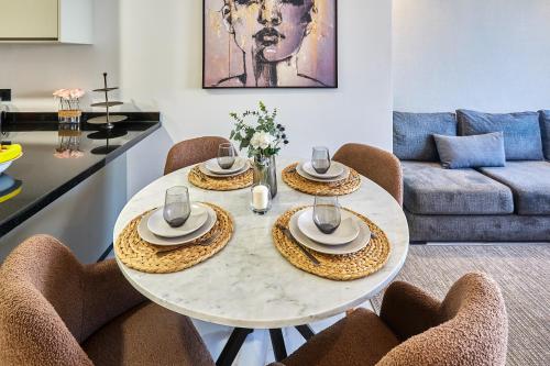 une salle à manger avec une table et des chaises blanches dans l'établissement Sleek and Modern 2-Bed Unit in Downtown Casa, à Casablanca