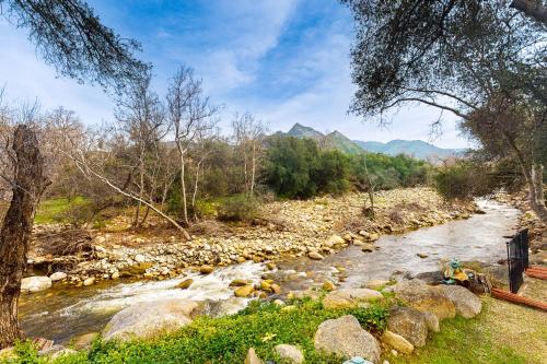 a river with rocks and trees and mountains in the background at Momma's Paradise in Three Rivers