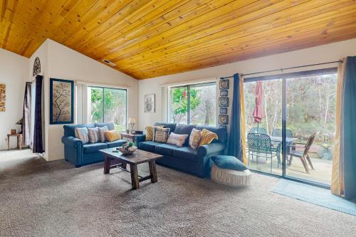 a living room with blue couches and a table at Momma's Paradise in Three Rivers