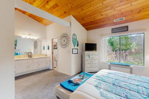 a bedroom with a bed and a bathroom with a sink at Momma's Paradise in Three Rivers